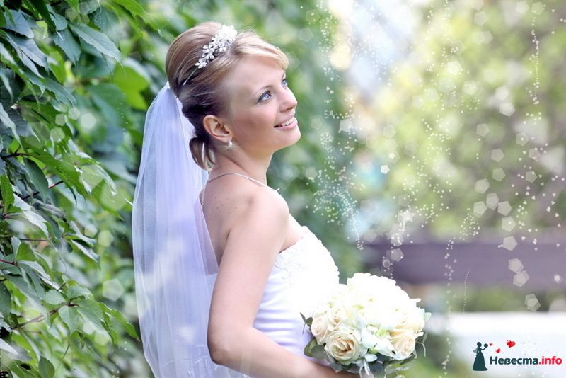 Невеста с букетом белых цветов стоит на фоне зелёных кустов - фото 98342 Фотограa Владимир Соколов
