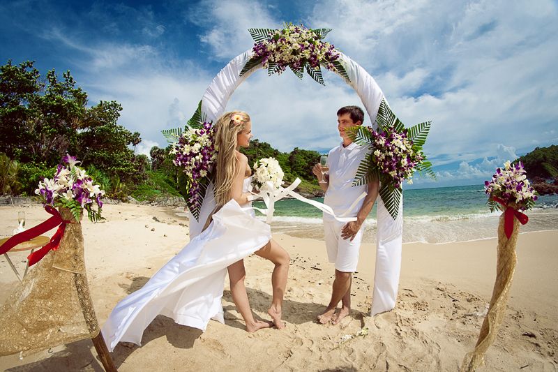 Под сводом свадебной арки стоят молодожены друг напротив друга, жених в белых бриджах и рубашке с бокалом шампанского в руке, - фото 977225 Фотограф Виталий Харин