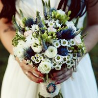 Оригинальный букет невесты из белых ранункулюсов, белых ромашек с голубым эрингиумом и вероникой