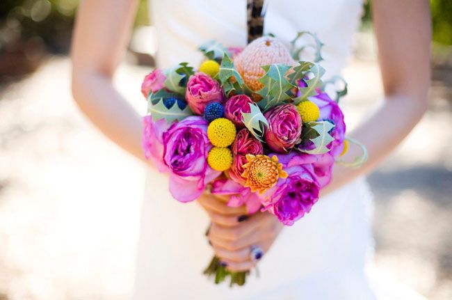 Яркий букет невесты из желтых краспедий, сиреневых и розовых пионовидных роз, оранжевых хризантем, зелени и розовой протеи  - фото 1183149 Свадебный распорядитель Дарья Емельянова