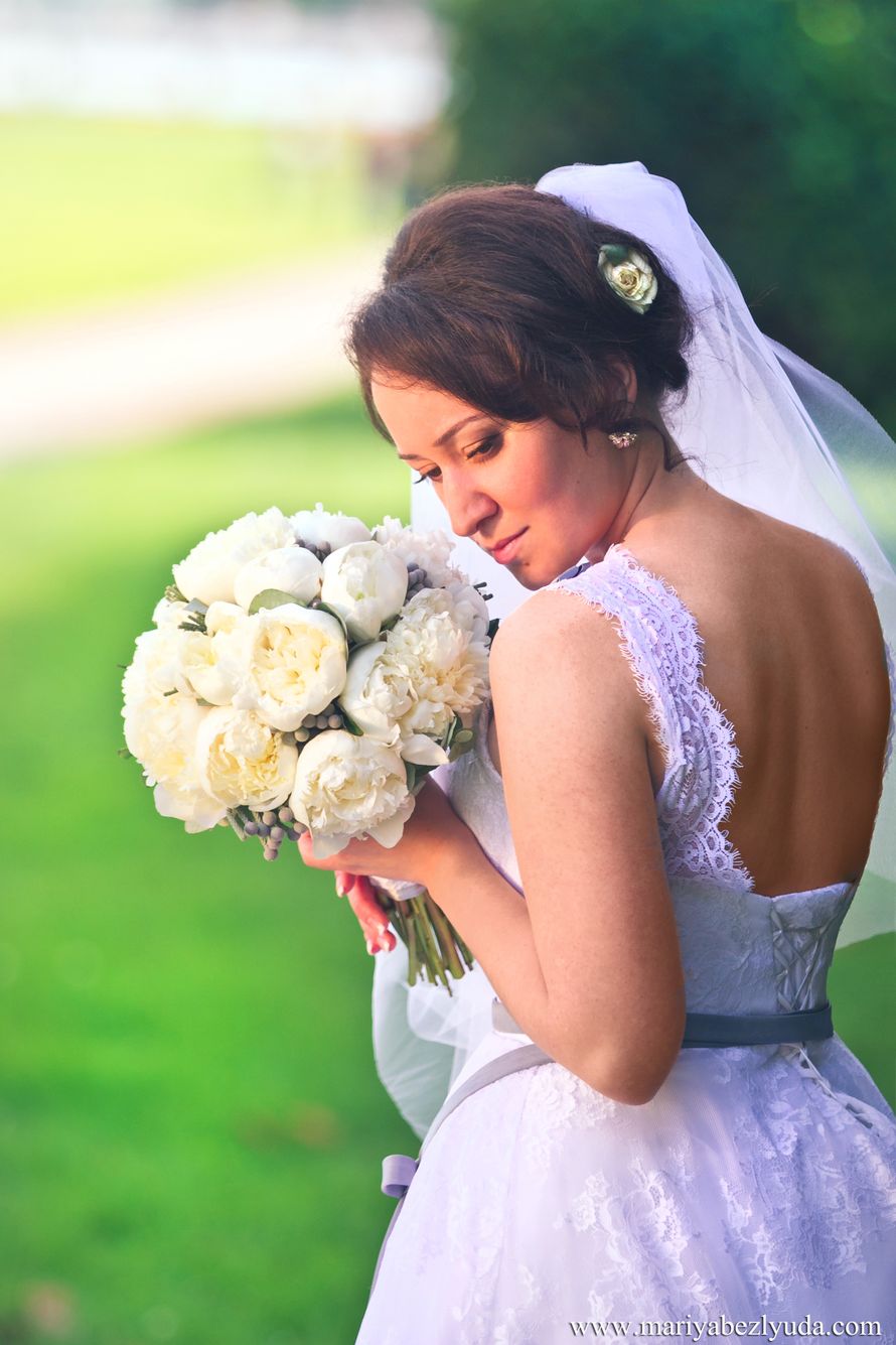 Романтический образ невесты выражен в прическе из длинных локонов собранных в  пучок на затылке с фатой, украшена белой розой - фото 2709827 Фотограф Мария Безлюда