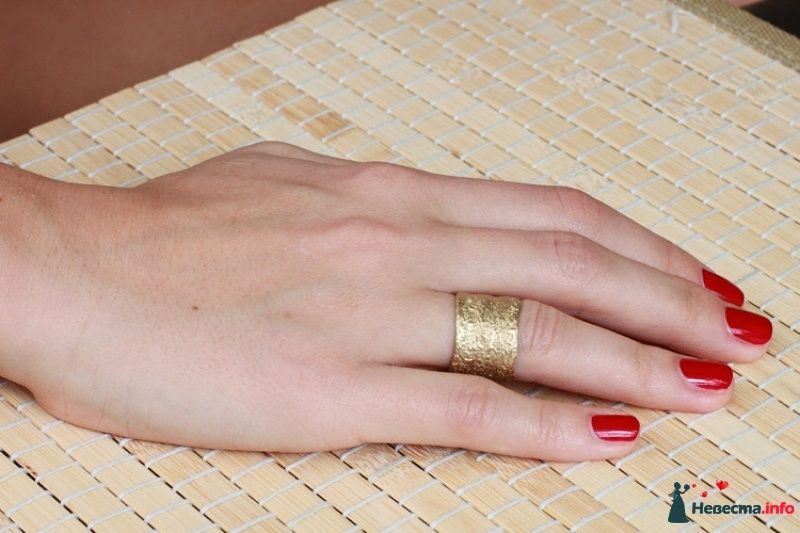 Широкое обручальное кольцо с рифленой поверхностью на руке невесты. - фото 441041 наперегонки