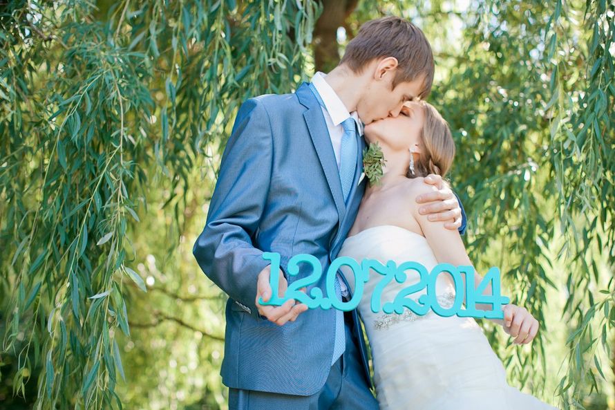 Держа в руках голубую табличку, жених и невеста целуются - фото 3002971 irinka525