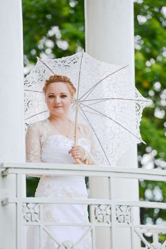 Невеста держит в руке белый кружевной зонтик - фото 1780576 Фотограф Кристина Фарнакеева