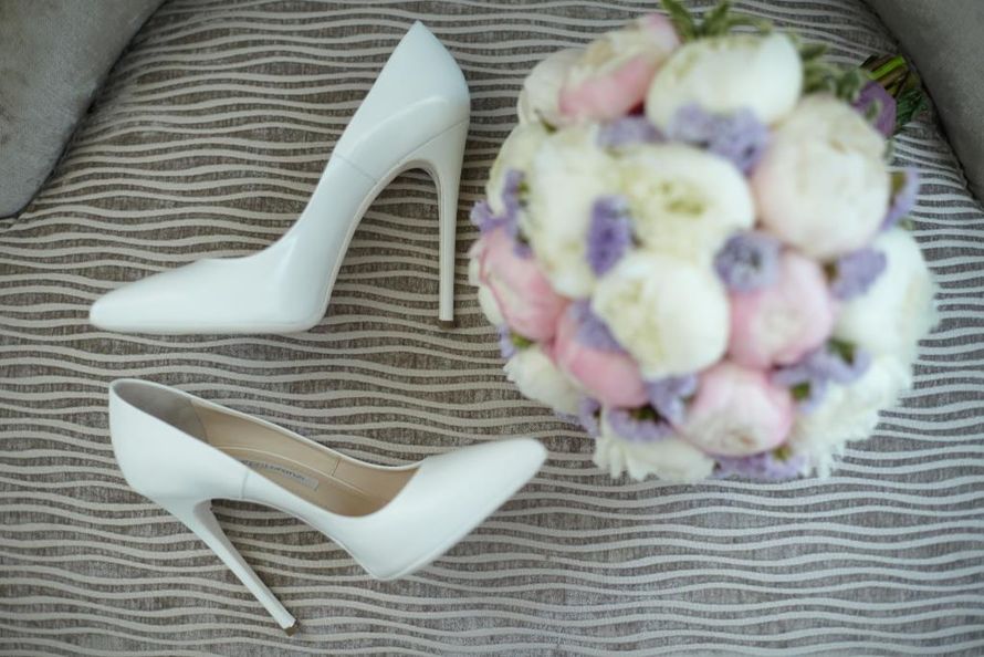 Белые кожаные туфли лежат возле букета цветов.  - фото 3141159 ThatONE Event - студия организации свадеб