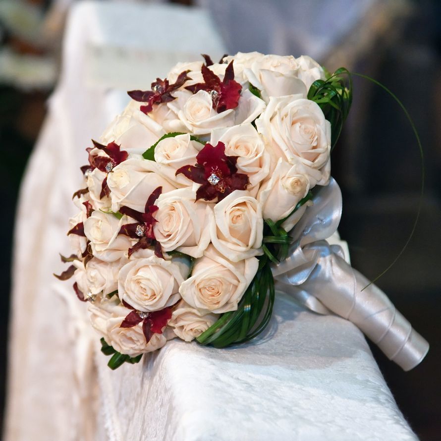 Букет невесты из белых роз и бордовых орхидей, декорированный белой атласной лентой  - фото 1850765 Салон флористики Magique Fleur