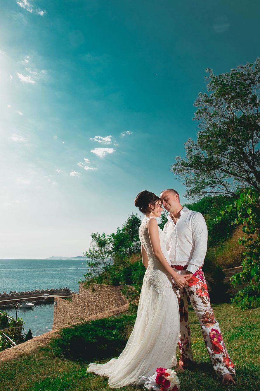 Жених и невеста, прислонившись друг к другу, стоят на фоне зелени и моря - фото 3594275 Parki Wedding - организация свадеб