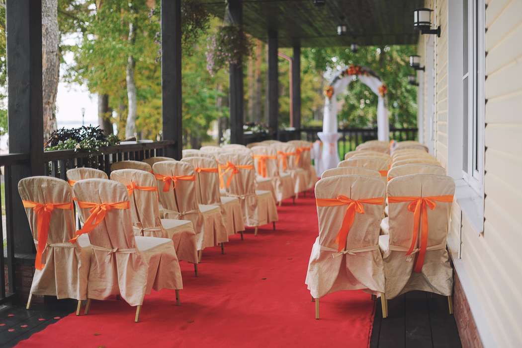Свадебная подковообразная арка для выездной церемонии на природе, увитая белой тканью с цветами, на фоне стульев для гостей - фото 2246858 Event-Reality - организация свадьбы