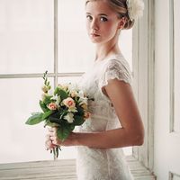 невеста с букетом стоит у окна