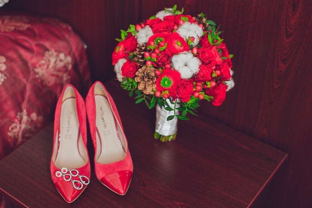 Зимний букет невесты из белого хлопка, красных роз, коричневых шишек и зелени с красными туфлями и серьгами-подвесками невесты с - фото 3652177 Организация и оформление свадьбы Sweet Day