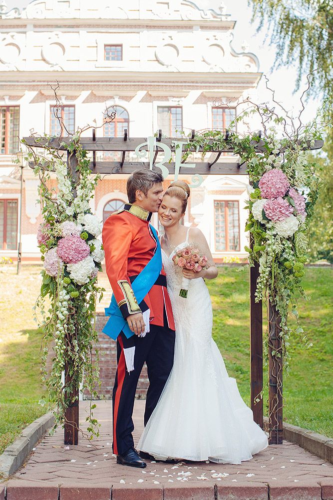 Жених и невеста, прислонившись друг к другу, стоят на фоне здания под аркой - фото 3051909 EkaterinaTeb