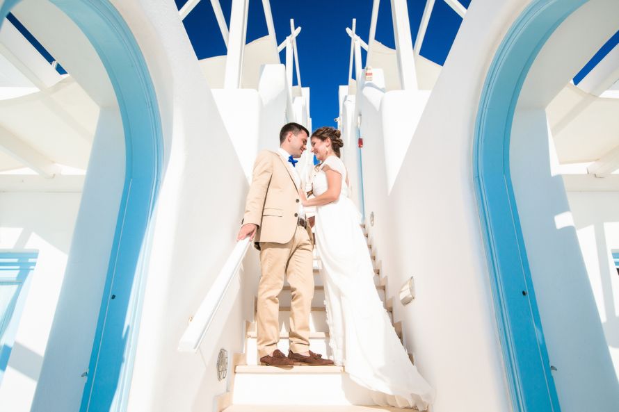 Жених и невеста, прислонившись друг к другу, стоят налестнице - фото 3470823 Santoweddings - свадьбы на Санторини