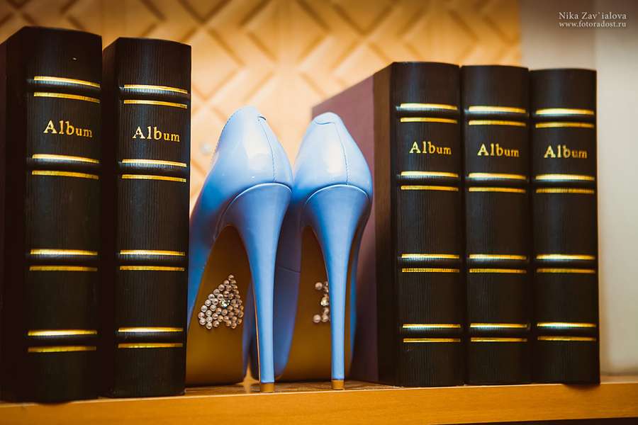 Голубые туфли на высоком каблуке стоят на полке между книг, на подошве приклеены камни в виде сердца. - фото 1403735 Фотограф Ника Завьялова