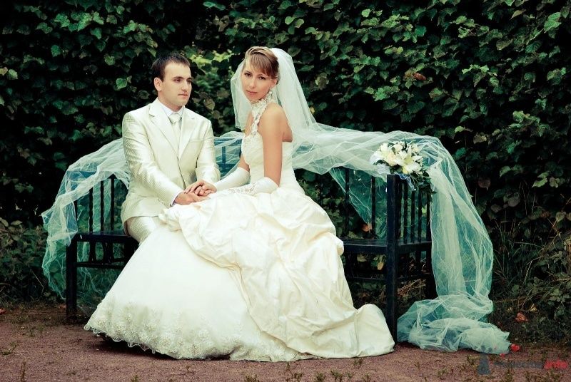 Жених и невеста сидят, прислонившись друг к другу, на скамейке в парке - фото 45912 musti