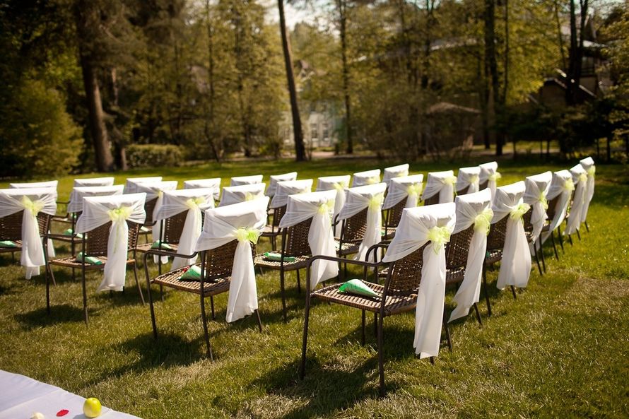 Стулья для гостей на выездной свадебной церемонии, украшенные белыми чехлами и желтыми лентами - фото 1902677 Полина Коровина флорист-дизайнер